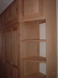 Fitted wardrobe in oak with integrated shelving.